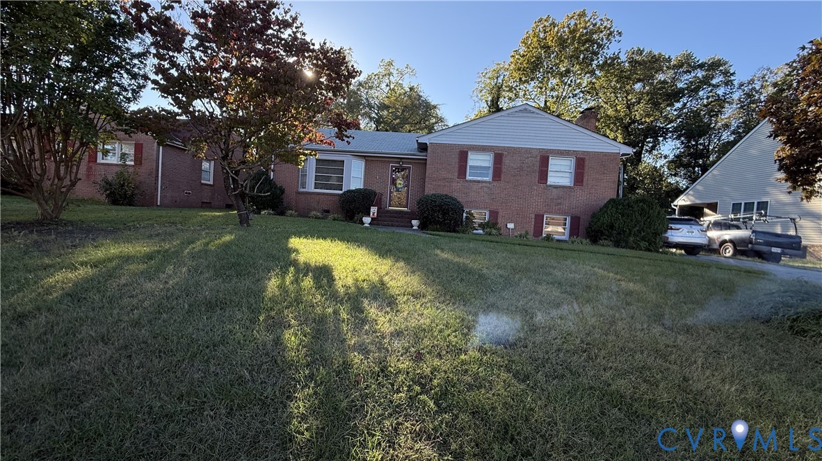 Brick exterior featuring a gabled roofline, light-colored siding, decorative shutters, and a detached garage Brick exterior featuring a gabled roofline, light-colored siding, decorative shutters, and a detached garage
