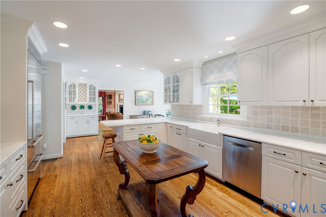 Stainless appliances include a gas cooktop and Sub-Zero refrigerator with two freezer drawers.