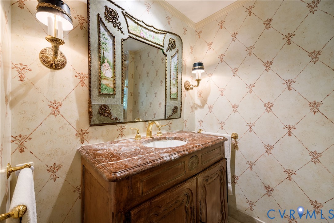 The primary bath features a wood cabinet/vanity with marble counter and decorative mirror.