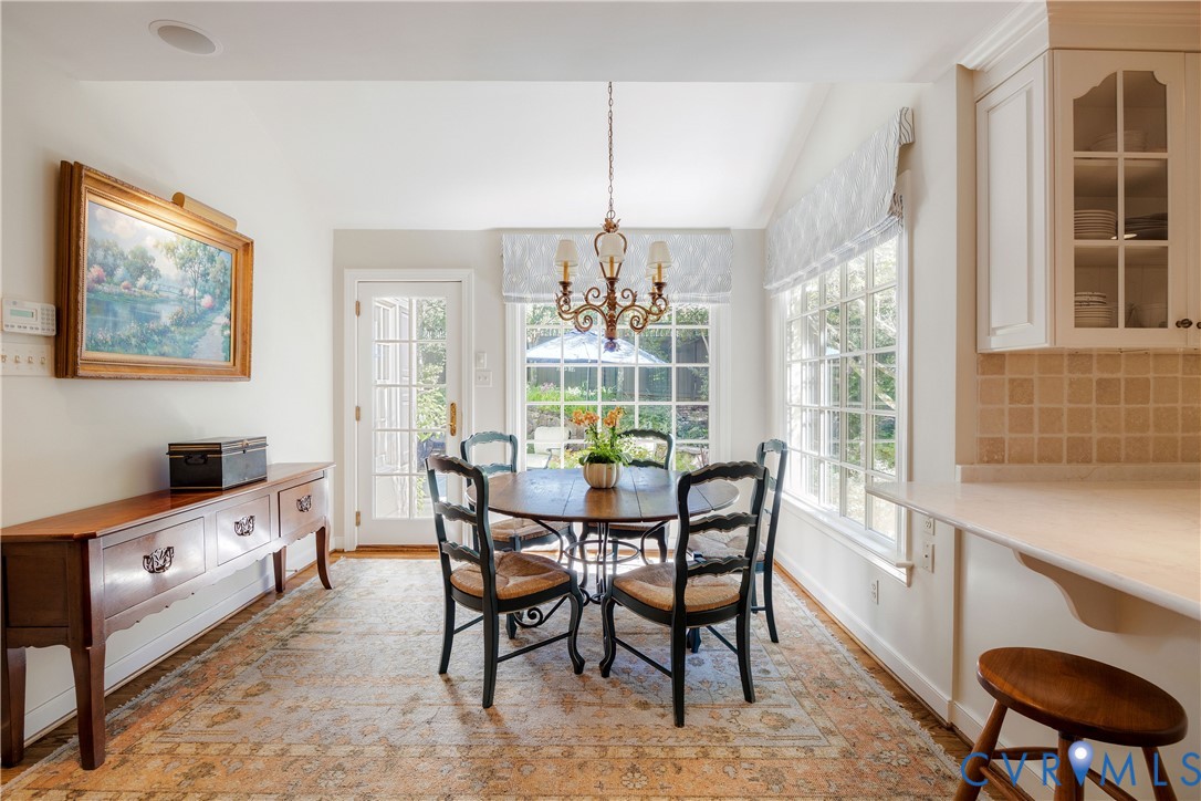 The casual dining area features a vaulted ceiling and large windows looking out to the gardens and private rear terraces.