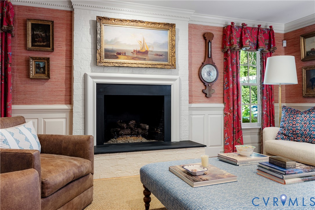 Painted brick fireplace with gas logs features black hearth and surround plus decorative crown moulding and wainscoting.