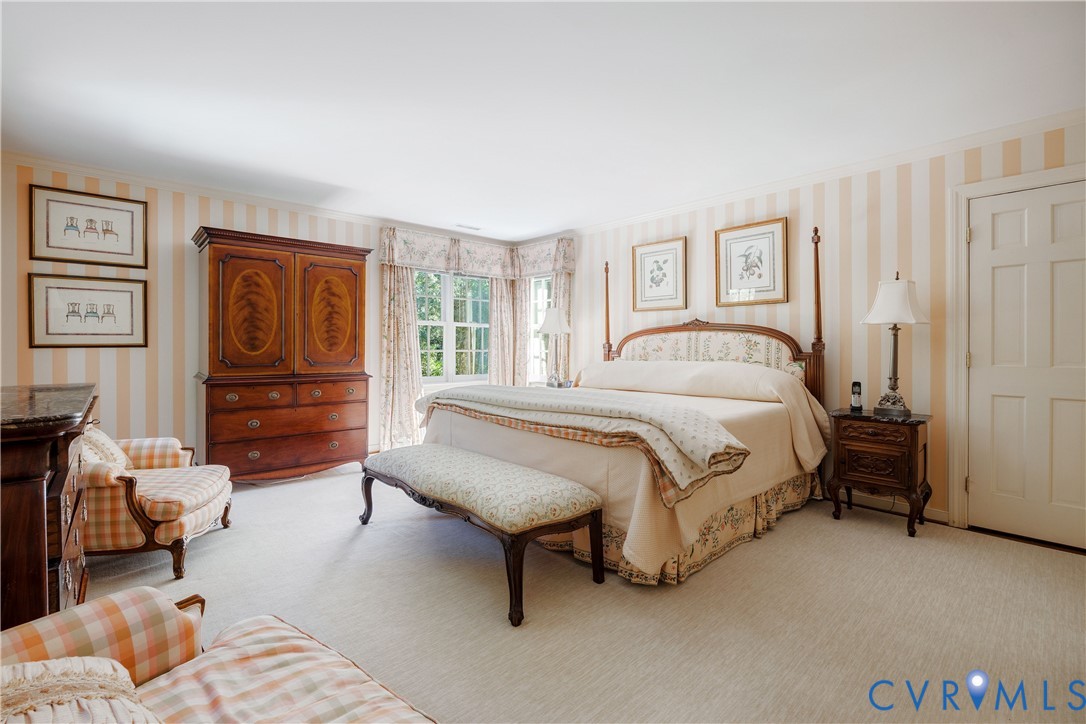 The primary bedroom features wall-to-wall carpeting, a windowed corner alcove and two double closets.