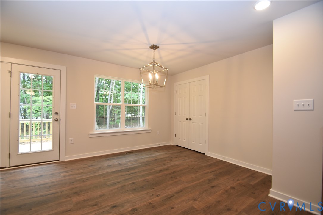 Wood-finish flooring, lantern-style pendant light fixture, double-door closet, multi-lite glass door, and double-hung window