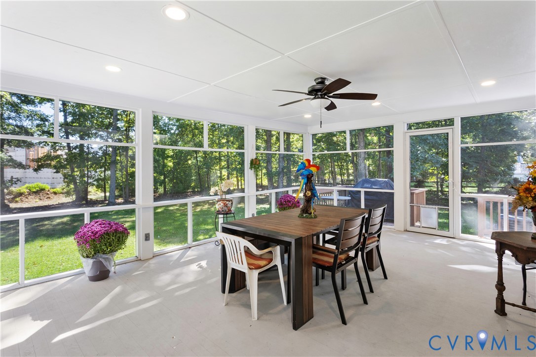 Screened-in porch featuring expansive floor-to-ceiling windows, recessed lighting, and a ceiling fan