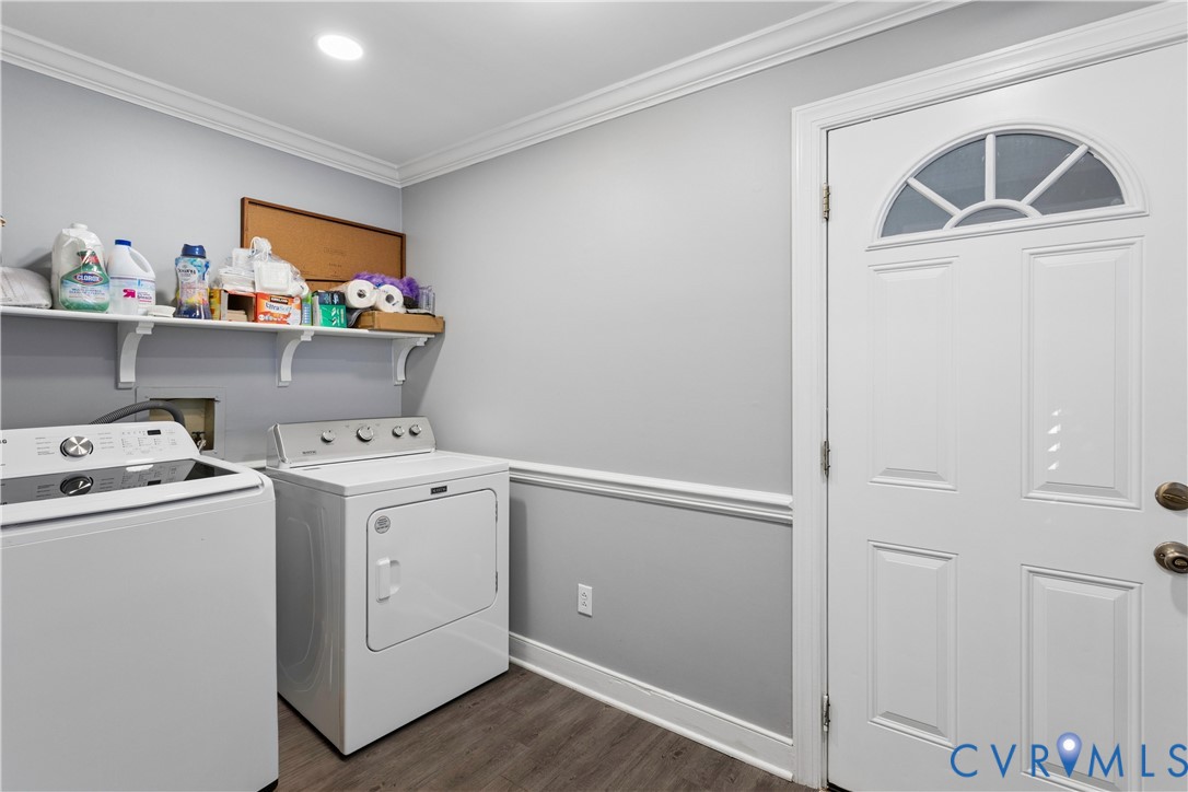 Utility room featuring wood-finish flooring, crown molding, chair rail trim, and a six-panel exterior door with an arched glass insert