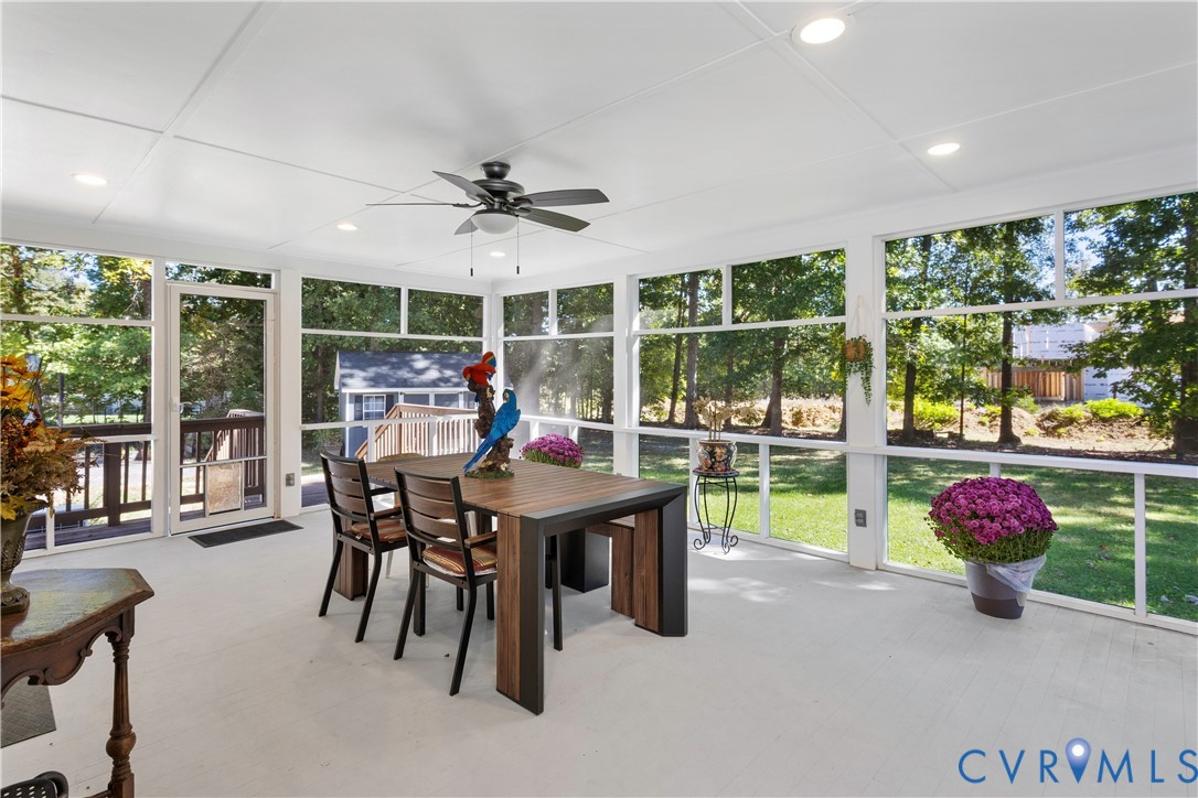 Screened-in porch featuring a flat ceiling with recessed lighting, a central ceiling fan, and extensive floor-to-ceiling screen panels