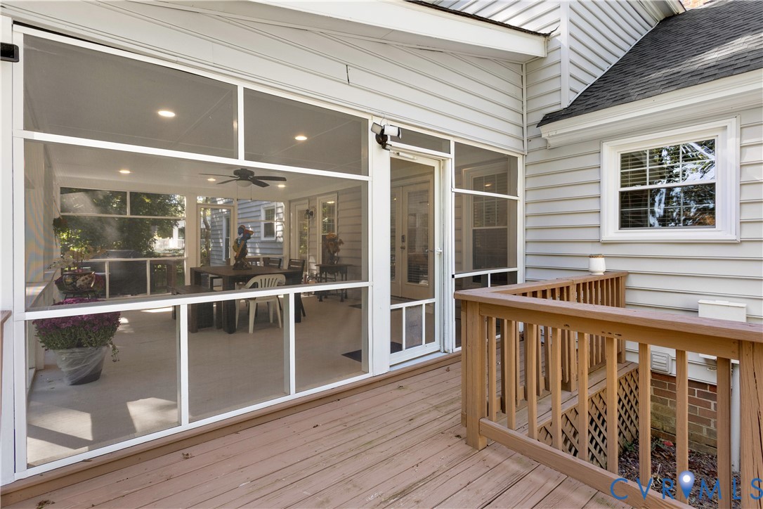 Screened-in porch featuring recessed lighting, a ceiling fan, and painted siding exterior with a wood deck and railing