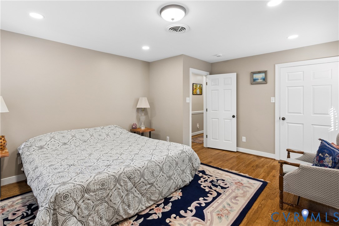 Wood-finish flooring, neutral wall paint, recessed lighting, and six-panel interior doors