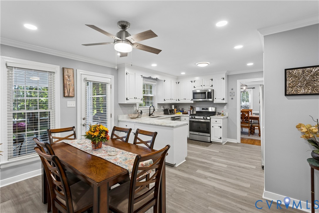 Kitchen featuring white shaker-style cabinetry, stone-finish countertops, stainless steel appliances, recessed lighting, and wood-finish flooring