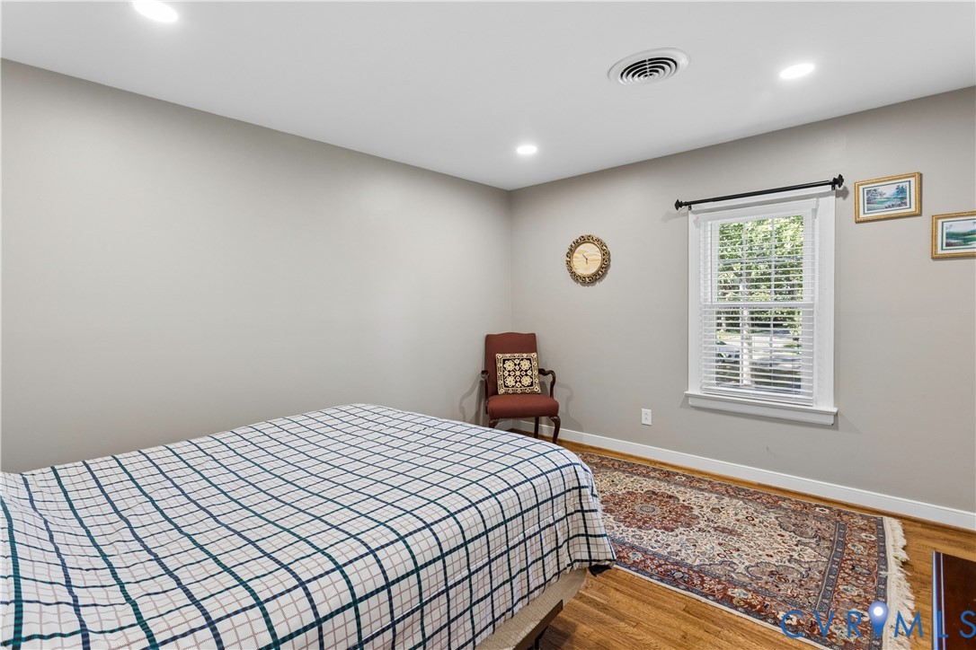 Neutral wall color, wood-finish flooring, recessed lighting, and a window with white trim
