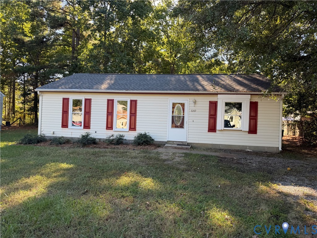 Single-story exterior featuring light-toned vinyl siding, contrasting decorative shutters, an asphalt shingle roof, a front entry door with glass insert, and a bay window Single-story exterior featuring light-toned vinyl siding, contrasting decorative shutters, an asphalt shingle roof, a front entry door with glass insert, and a bay window