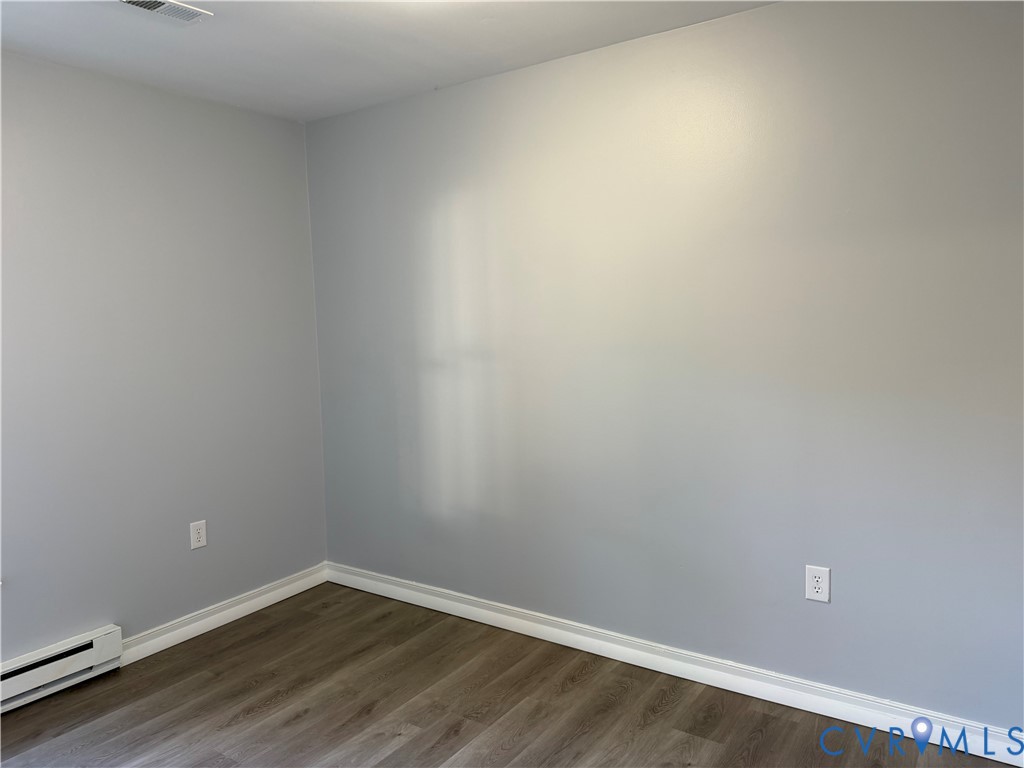Neutral-toned interior walls featuring wood-finish flooring and white trim