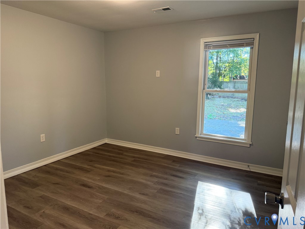 Interior space featuring wood-finish flooring, light-toned wall paint, and a single-hung window with casing