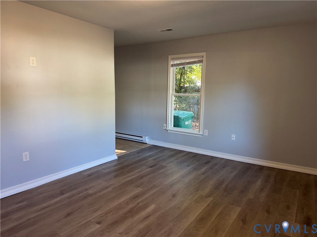 Room featuring wood-finish flooring, neutral wall paint, and a single-pane window