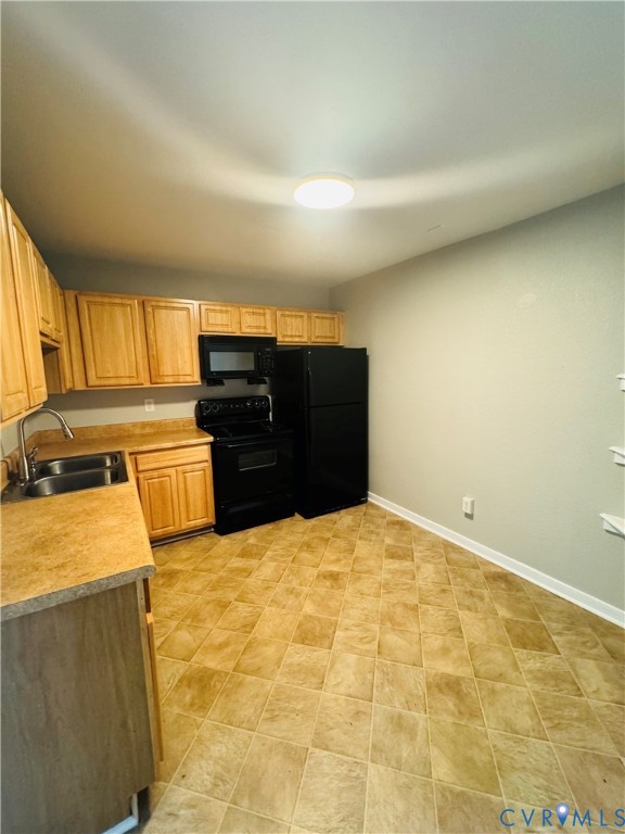 Kitchen featuring light wood-finish cabinetry and laminate countertops