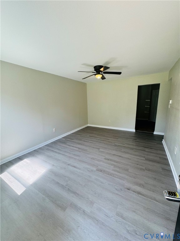 Neutral interior space featuring laminate flooring and a central ceiling fan