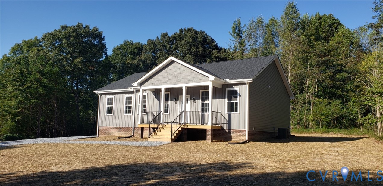 Single-story residence featuring vinyl siding, a brick foundation, a gable roofline, and a covered front porch with a metal railing