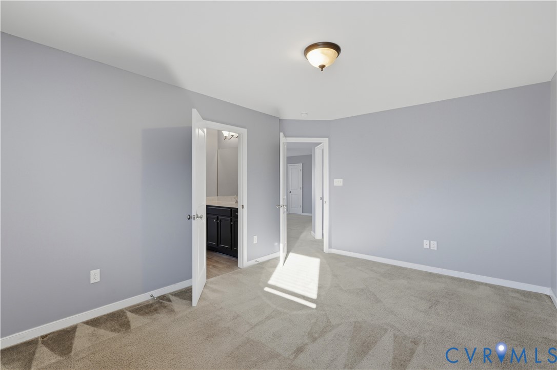 Bedroom #3 Neutral-toned wall paint, neutral carpeting, and a flush-mount ceiling light fixture