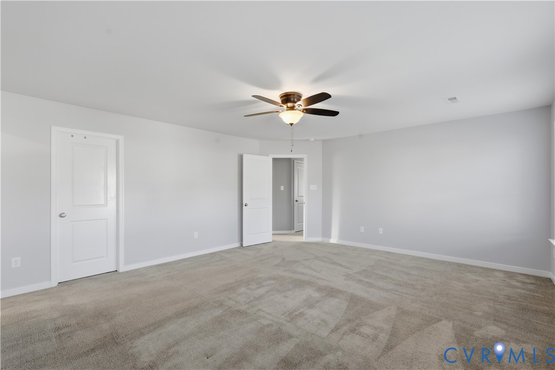 Upstairs Primary Bedroom or bedroom #2. Neutral interior room featuring neutral wall-to-wall carpeting, a central ceiling fan with integrated lighting, and white multi-panel interior doors