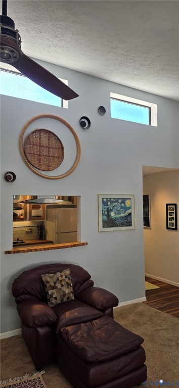 Vaulted ceilings featuring clerestory windows, a ceiling fan, and a built-in kitchen pass-through with a wooden ledge Vaulted ceilings featuring clerestory windows, a ceiling fan, and a built-in kitchen pass-through with a wooden ledge