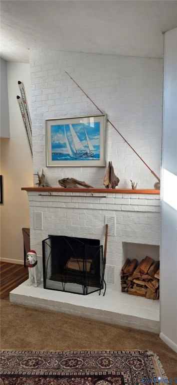 White painted brick fireplace featuring a wood mantel and an integrated firewood storage niche White painted brick fireplace featuring a wood mantel and an integrated firewood storage niche