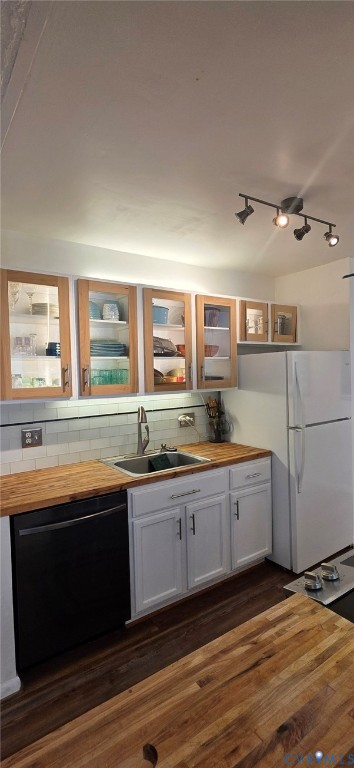 Kitchen featuring wood-finish countertops, white cabinetry, glass-front upper cabinets, white subway tile backsplash, and adjustable track lighting Kitchen featuring wood-finish countertops, white cabinetry, glass-front upper cabinets, white subway tile backsplash, and adjustable track lighting