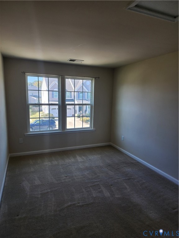 Neutral wall tones, wall-to-wall carpeting, and double-pane windows with integrated grille patterns