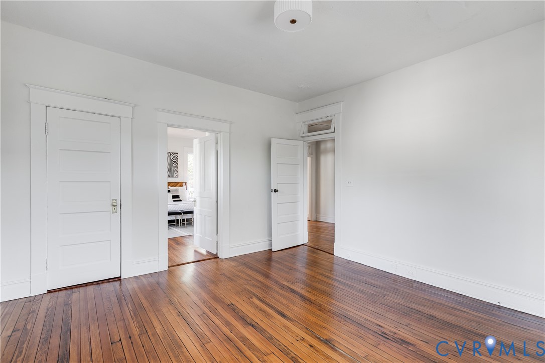 Wood-finish flooring, multi-panel interior doors, crisp white trim, and a transom window