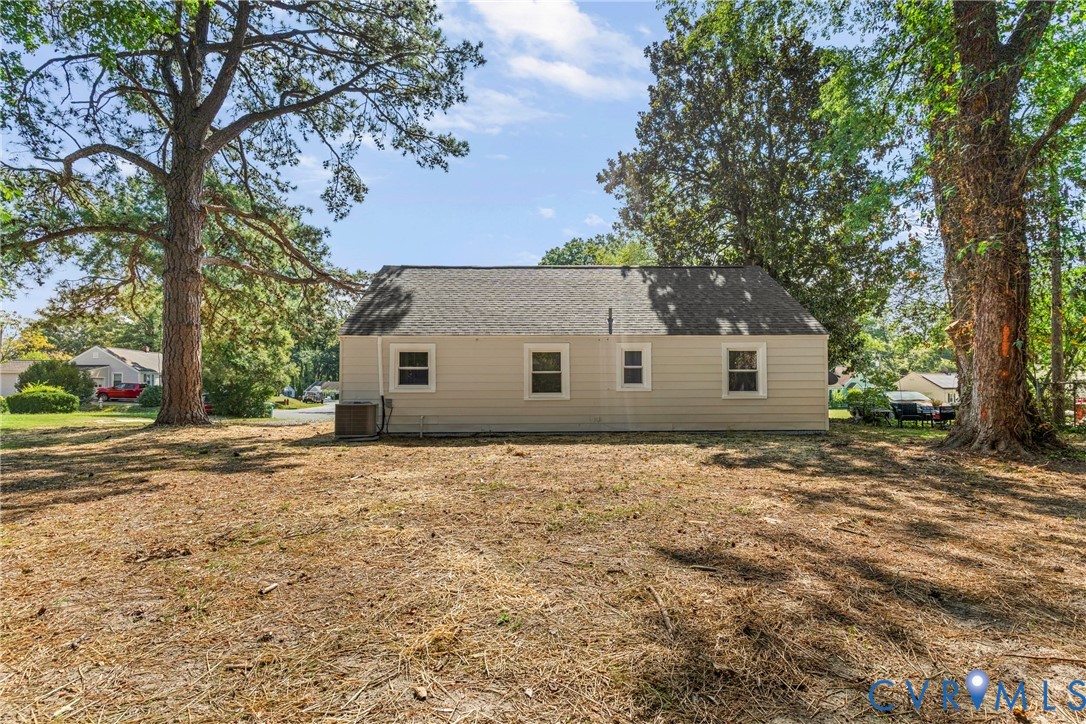 Single-story residence with light-colored siding, a dark shingle roof, and multiple windows