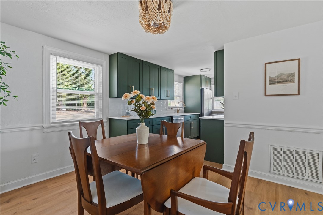 Wood-finish flooring, white walls with chair rail molding, and a decorative light fixture