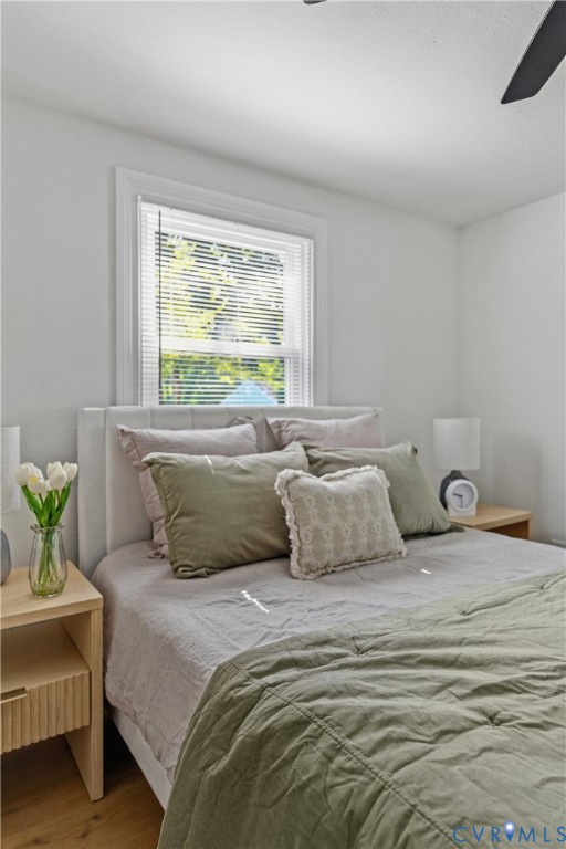 White interior walls, wood-finish flooring, and a single window with blinds