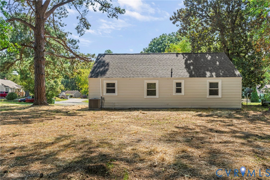 Exterior with light-colored siding, multiple windows, and a dark shingle roof