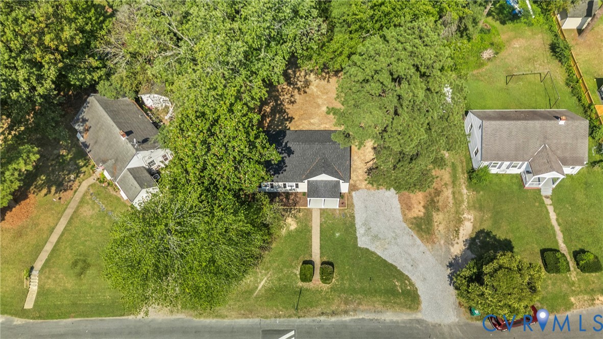 White exterior residence with a dark shingle roof, front porch, and a gravel driveway White exterior residence with a dark shingle roof, front porch, and a gravel driveway