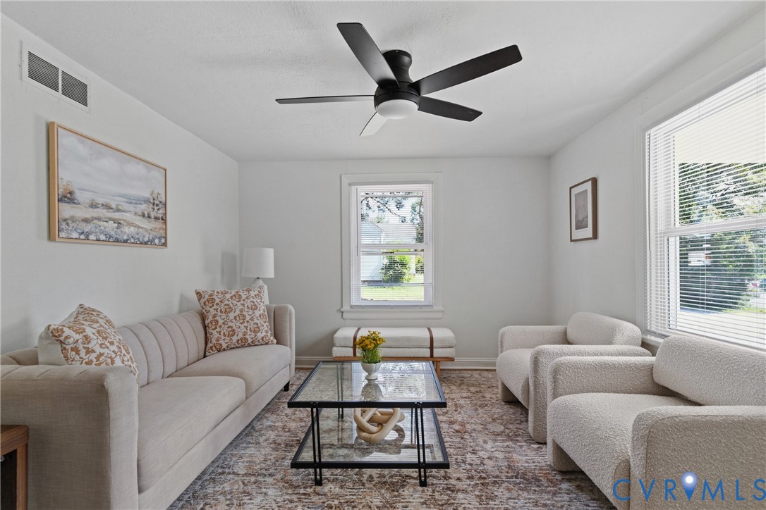 Recessed ceiling with a matte black ceiling fan, multiple windows with blinds, and light-toned wall finishes Recessed ceiling with a matte black ceiling fan, multiple windows with blinds, and light-toned wall finishes