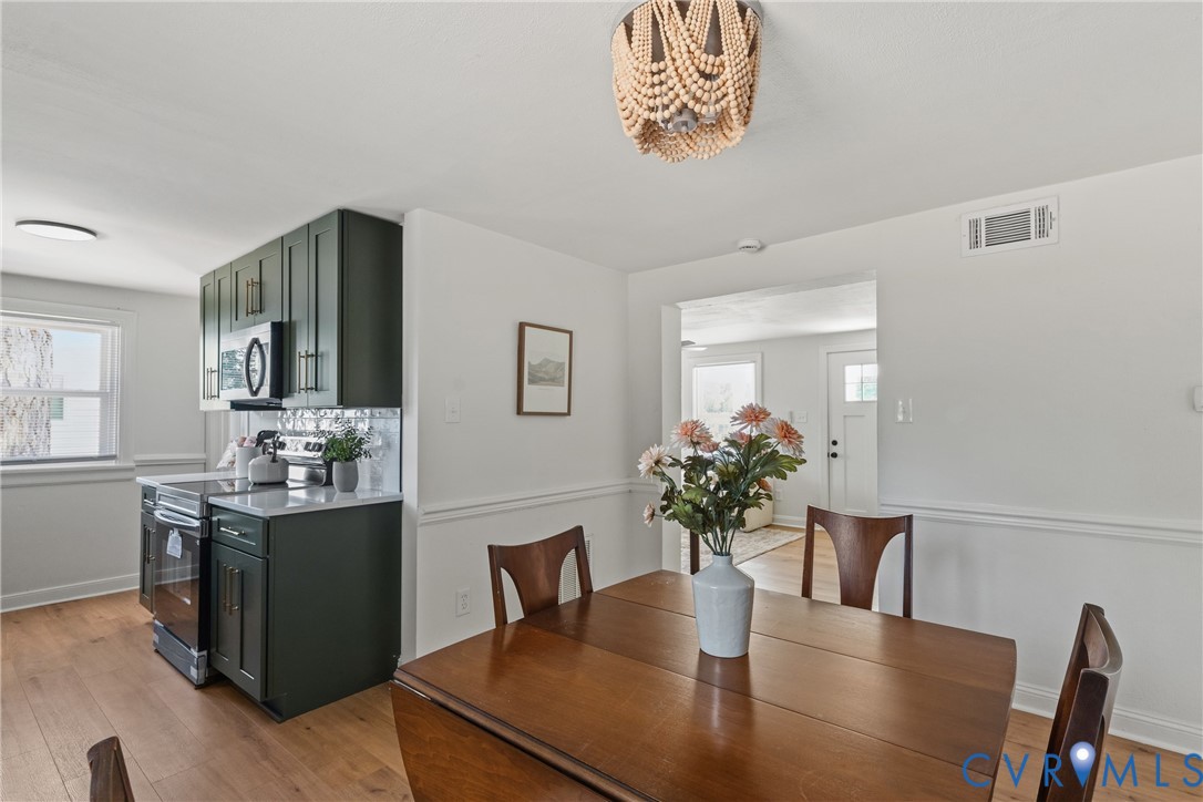 Kitchen with dark cabinetry, integrated microwave, and white countertops
