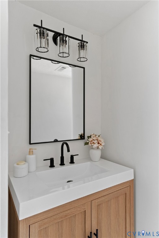 White integrated sink with a matte black faucet, set into a light wood-finish vanity with paneling