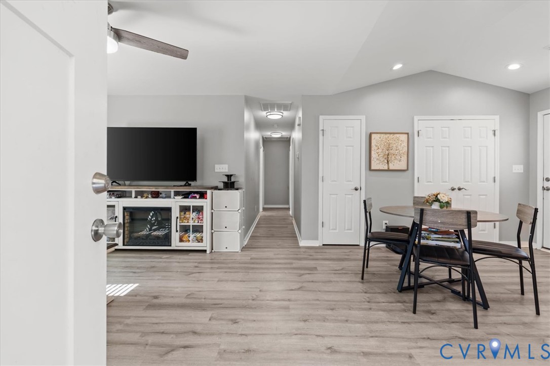 Vaulted ceilings, wood-finish flooring, recessed lighting, and multi-panel interior doors