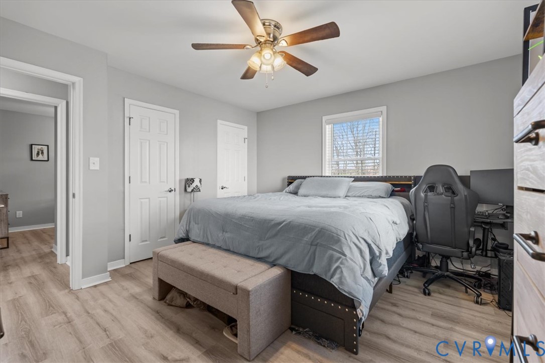 Neutral wall finishes, wood-finish flooring, ceiling fan with integrated lighting, and single-pane window