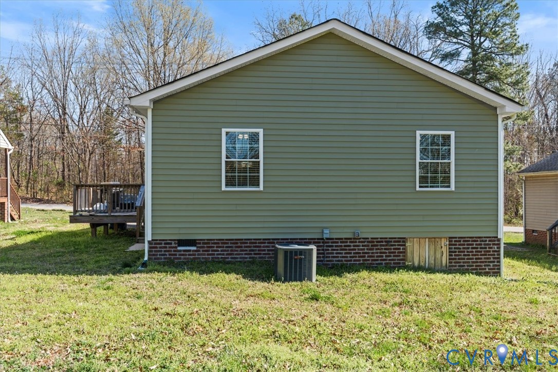 Exterior featuring horizontal siding, a brick foundation, gabled roofline, double-hung windows, and an attached wood deck