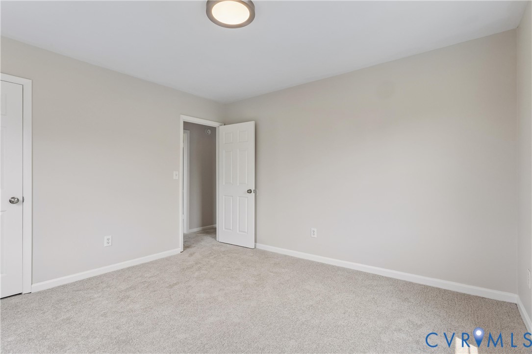 Neutral-toned wall paint, wall-to-wall carpeting, flush-mount circular lighting, and white-paneled interior doors with brushed nickel hardware