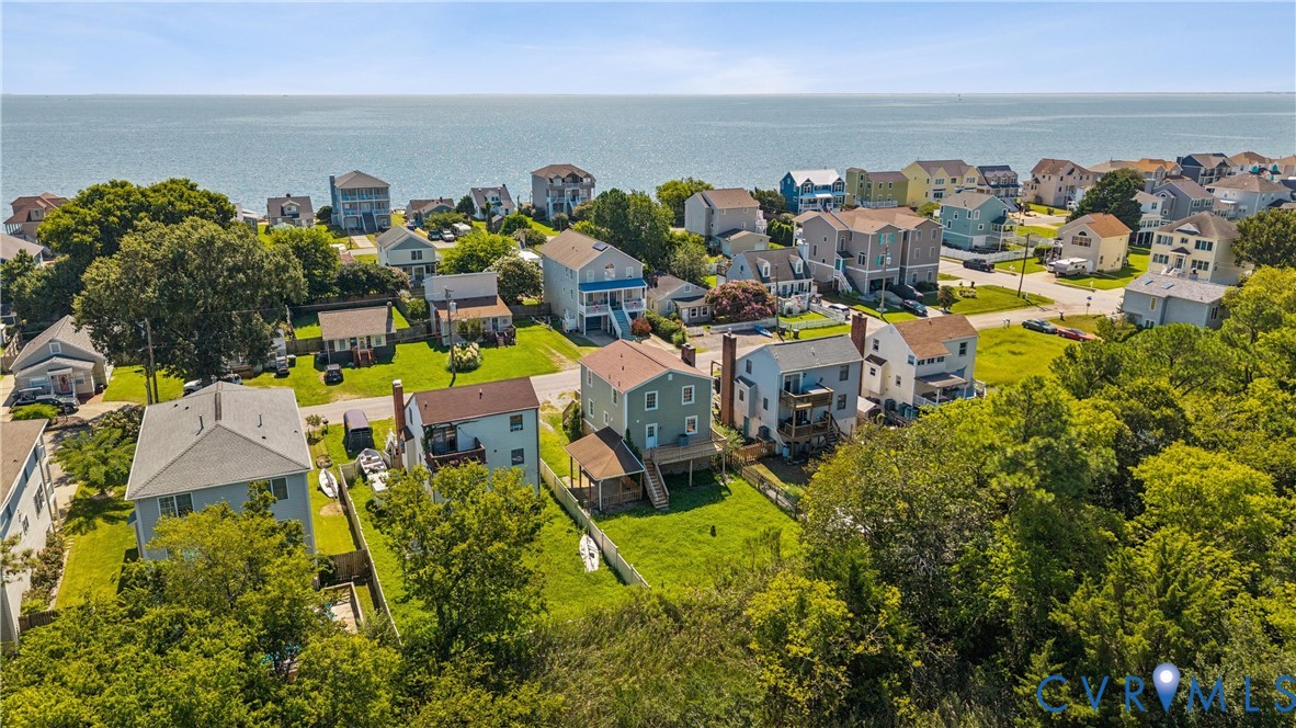 Aerial perspective featuring coastal residential lots, expansive turf lawns, and direct proximity to the open water