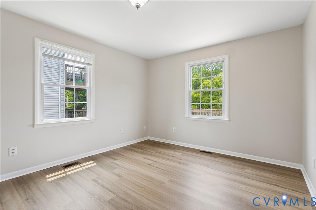 Neutral-toned walls, wood-finish flooring, and two double-hung windows