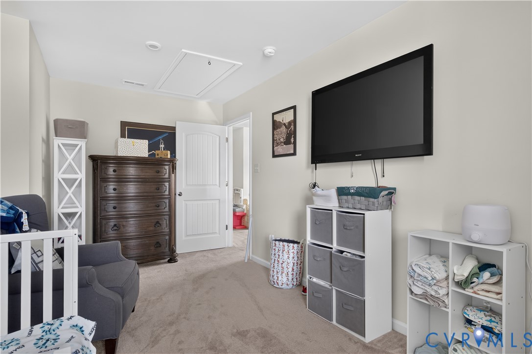 Neutral-toned room featuring plush wall-to-wall carpeting and a multi-panel interior door