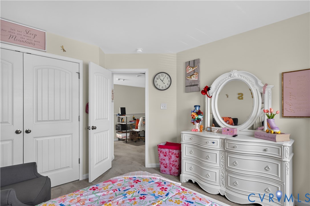 Room featuring neutral-toned walls, carpeting, and two-panel arch-top interior doors