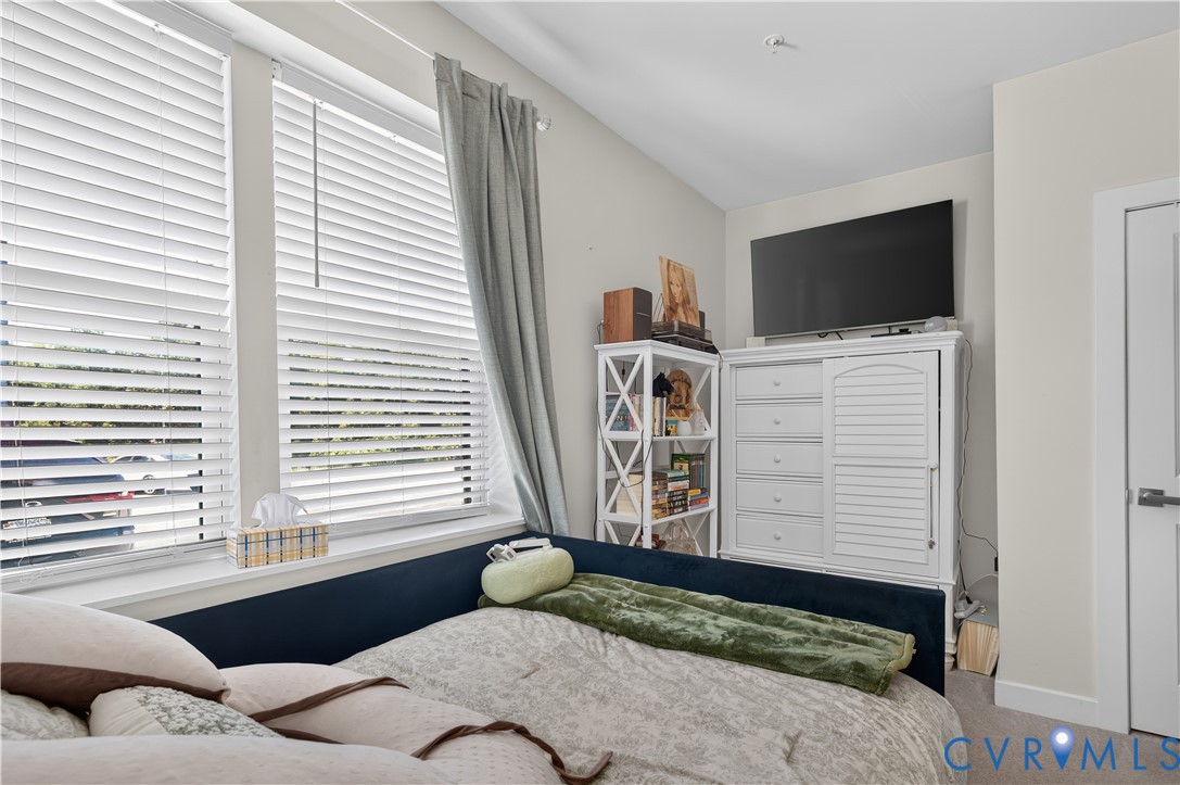 Neutral wall color, dual windows with horizontal blinds, and a white paneled door