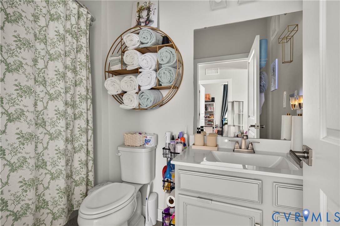Bathroom featuring a vanity with shaker-style cabinetry, an integrated rectangular sink, and a chrome faucet, complemented by a large frameless mirror