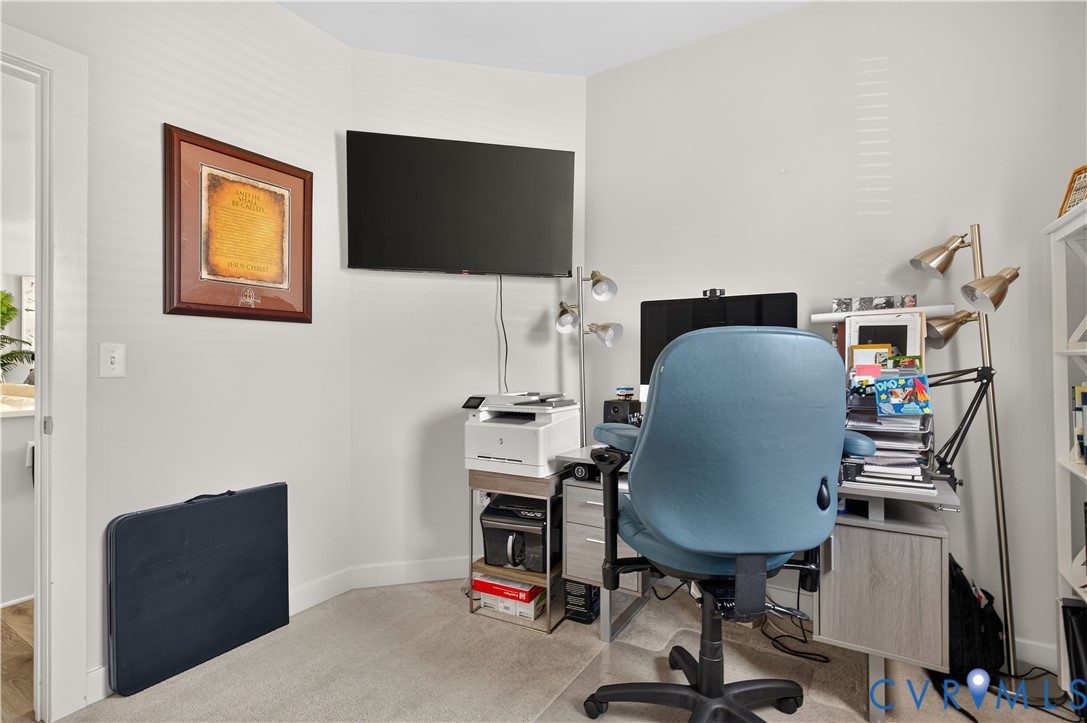 Corner space featuring neutral wall tones and wall-to-wall carpeting