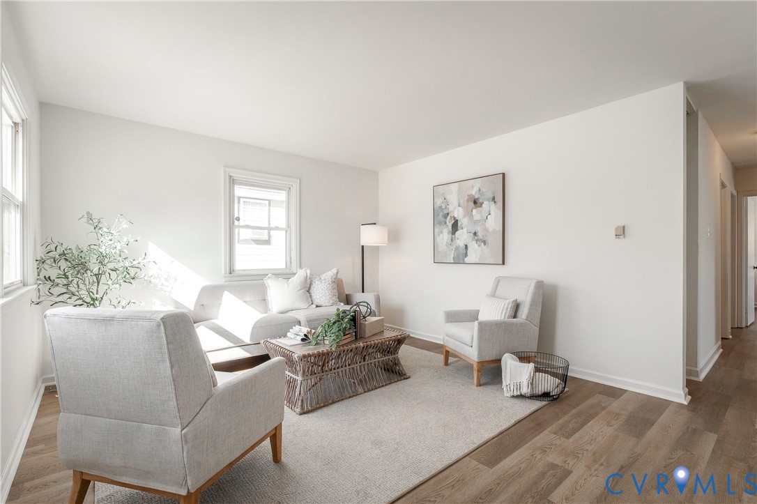 Neutral interior featuring wood-finish flooring, crisp white walls, and dual double-hung windows