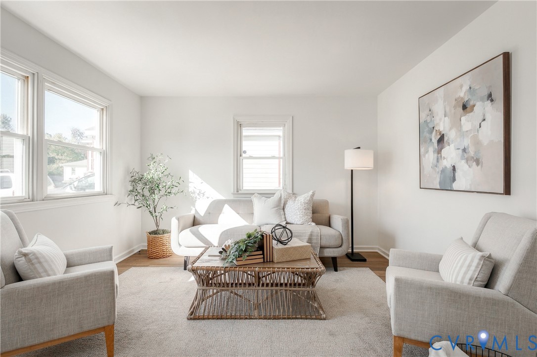Living area featuring wood-finish flooring, neutral walls, and multiple double-pane windows