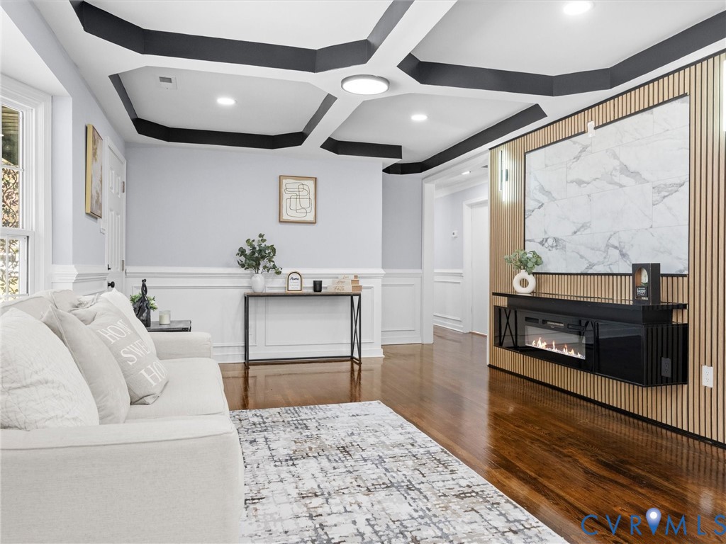 Coffered ceiling with contrasting trim, wood-finish flooring, and white wainscoting
